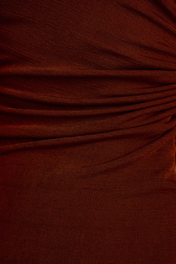 Close-up of ruched rust knit jersey fabric on the Aftergold midi dress.