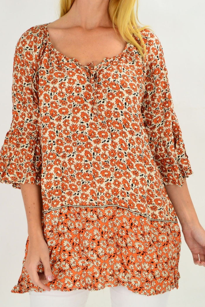 Fresh orange flower crinkle tunic top by Hourglass, lightweight with a flowy, textured fabric and floral design, displayed on a hanger.