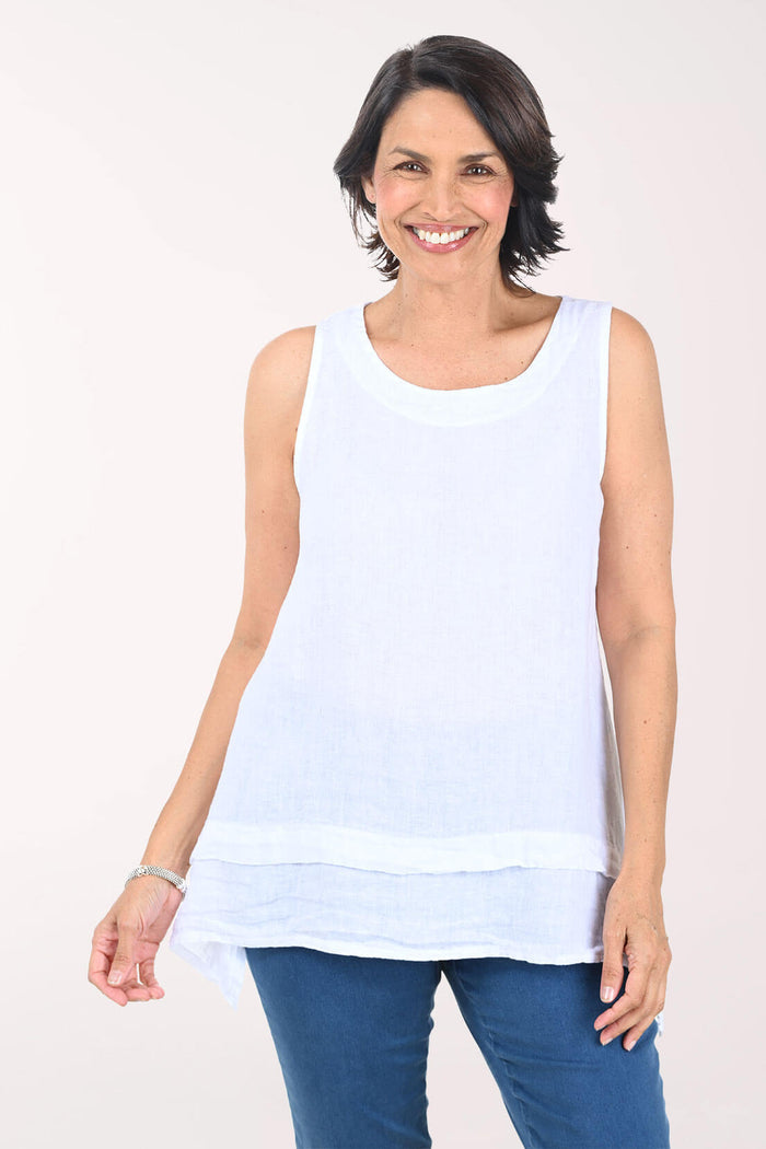 Woman wearing a white sleeveless top and blue jeans on a white background