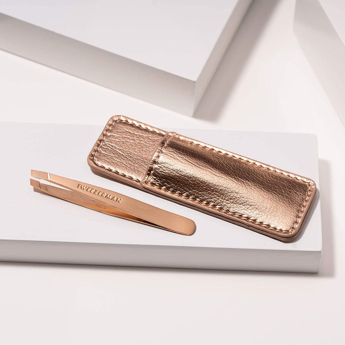 Rose Gold Mini Slant & Case | Tweezerman featuring a sleek rose gold slant tweezer with engraved branding and a matching textured metallic rose gold carrying case for on-the-go grooming.