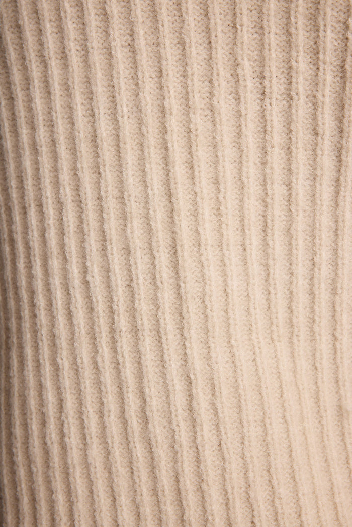 Full-length view of the cream sweater showing the drape and movement.