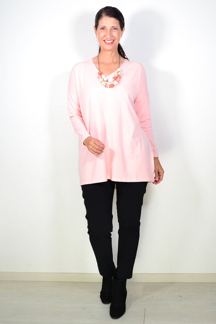 Blush pink wool blend fine knit tunic top by Cali&Co, shown hanging on a wooden hanger with a soft, textured fabric appearance.