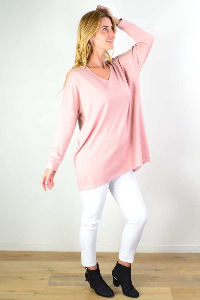 Blush pink wool blend fine knit tunic top by Cali&Co displayed on a hanger, showcasing its soft texture and relaxed fit.
