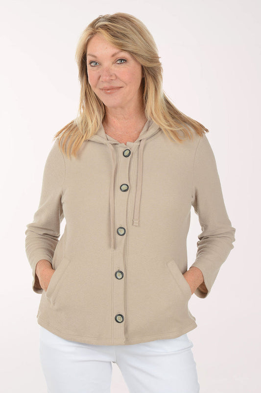 Woman wearing a beige jacket with black buttons on a white background