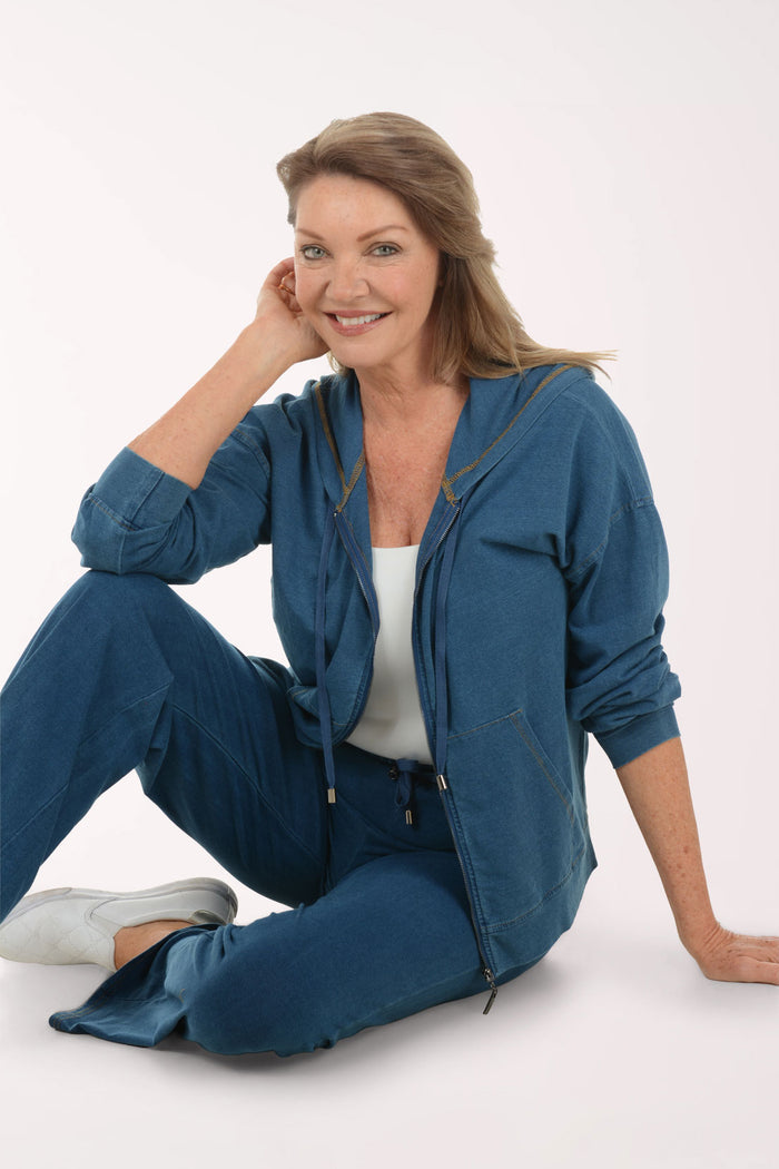 Woman wearing a blue tracksuit sitting on a white background