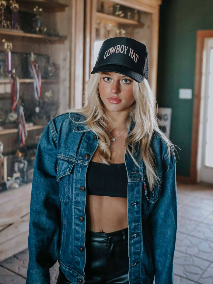 Woman in denim jacket and Cowboy Hat cap.