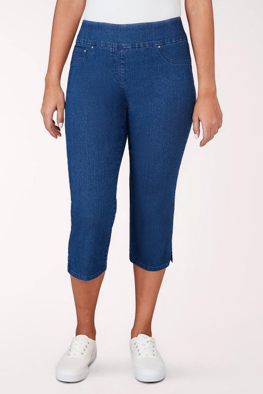 Person wearing blue denim capri pants on a white background