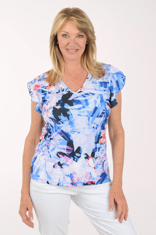 Woman wearing a colorful butterfly-patterned top on a white background