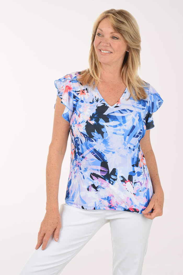Woman wearing a colorful butterfly-patterned top on a white background
