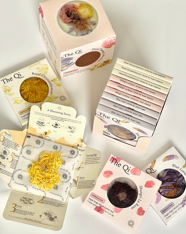 Assorted floral teas in elegant pastel boxes displayed with open packaging revealing dried flowers and detailed wellness benefits, showcasing Floral Collection (Variety Box) | The Qi.