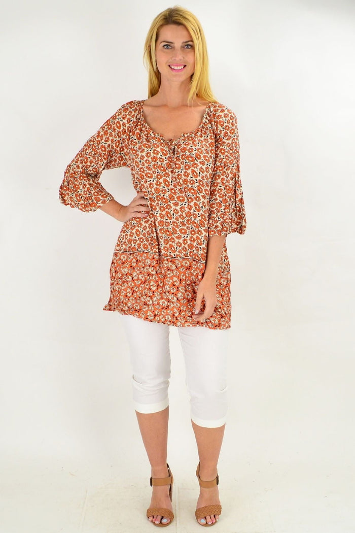 Fresh orange flower crinkle tunic top by Hourglass, lightweight with floral pattern, shown on a hanger.