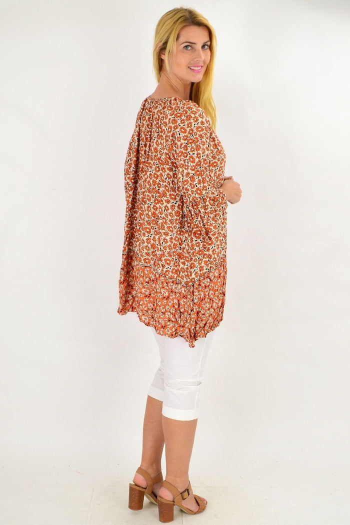 Fresh orange flower crinkle tunic top by Hourglass, displayed on a hanger with detailed texture and vibrant color.