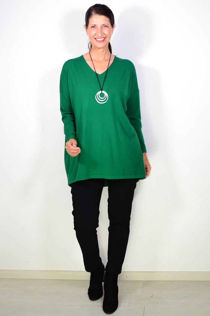 Green wool blend fine knit tunic top by Cali&Co, close-up of the textured fabric and neckline on a plain background.