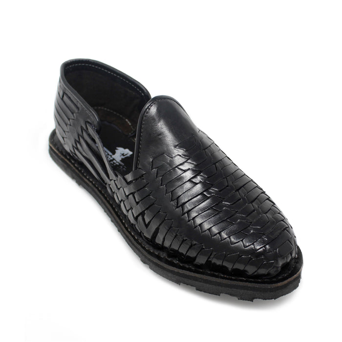 Men's handmade black genuine leather huarache sandals featuring traditional woven Mexican craftsmanship, closed-toe slip-on design, leather-lined interior, cushioned footbed, and durable flexible outsole for everyday comfort.