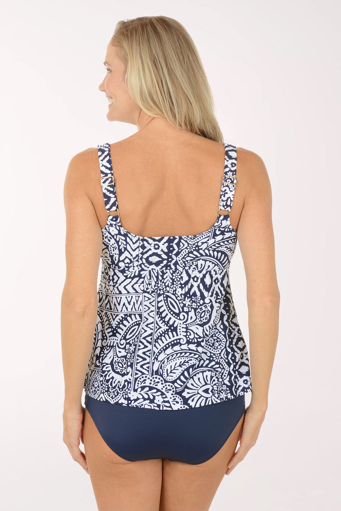 Woman wearing a navy and white patterned tankini top on a white background