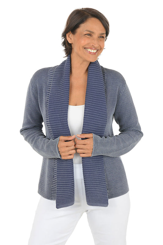 Woman wearing a blue knitted cardigan over a white top on a white background.