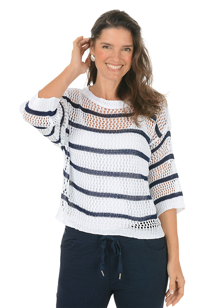 Woman wearing a white and navy striped sweater on a white background.
