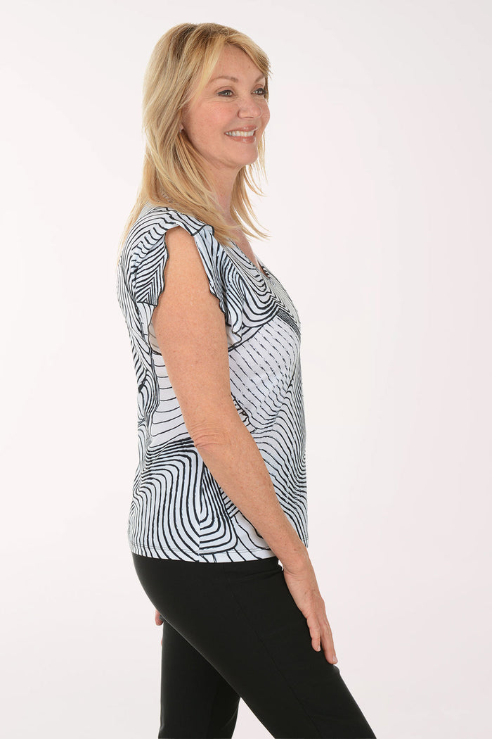 Woman wearing a black and white patterned top on a white background