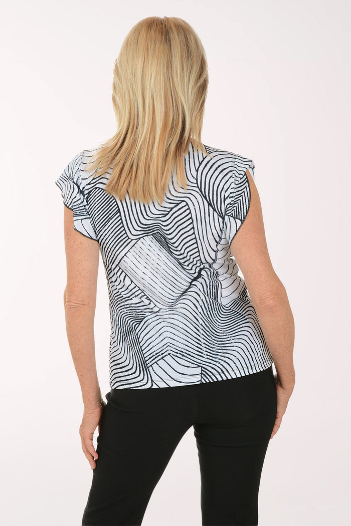 Woman wearing a black and white patterned top on a white background