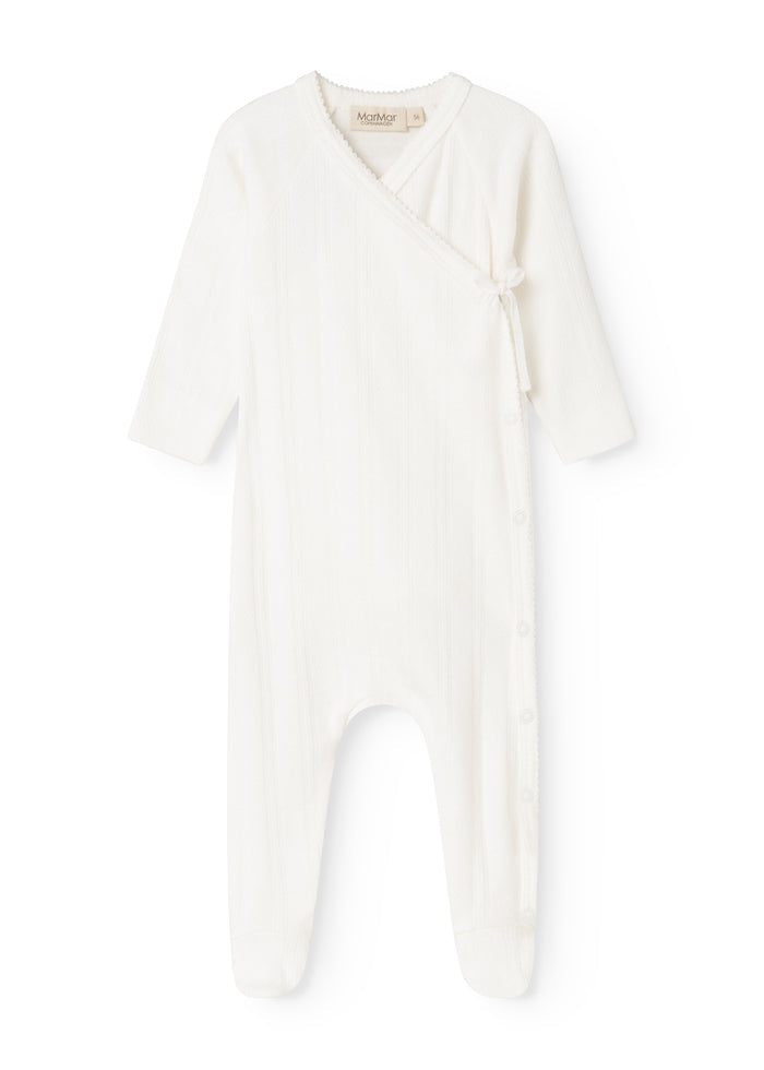 Baby romper in cream white with button closure in front and long sleeves.