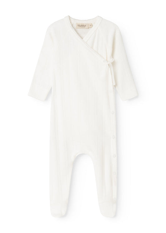 Baby romper in cream white with button closure in front and long sleeves.
