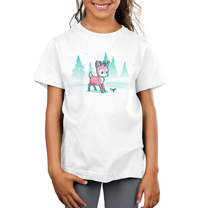 Premium Cotton T-shirt_TeeTurtle white Winter Wonderland apparel featuring a cartoon deer with small antlers stands in a snowy landscape with evergreen trees, looking curiously at a glowing sprout on the ground. Snowflakes are falling around them.